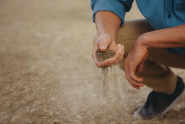 uomo con terra secca in mano