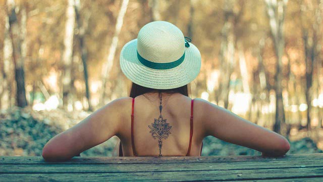 ragazza nella natura schiena tatuata