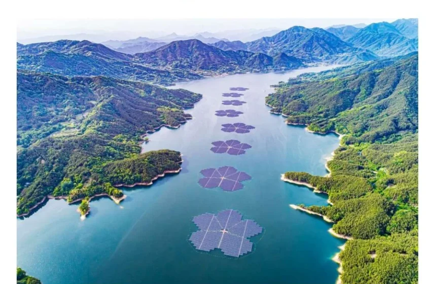 Impianto fotovoltaico galleggiante a forma di fiore su un lago tra le montagne, tecnologia solare flottante applicata a un bacino idrico