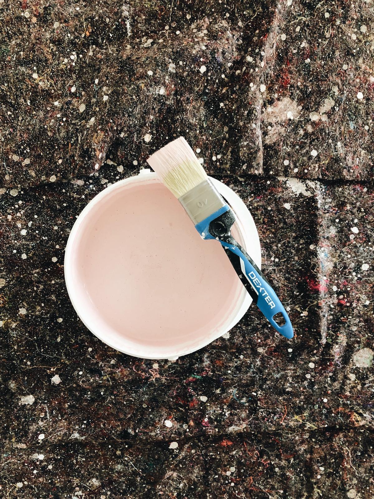 Illustrazione di una persona che vernicia una parete con un pennello.